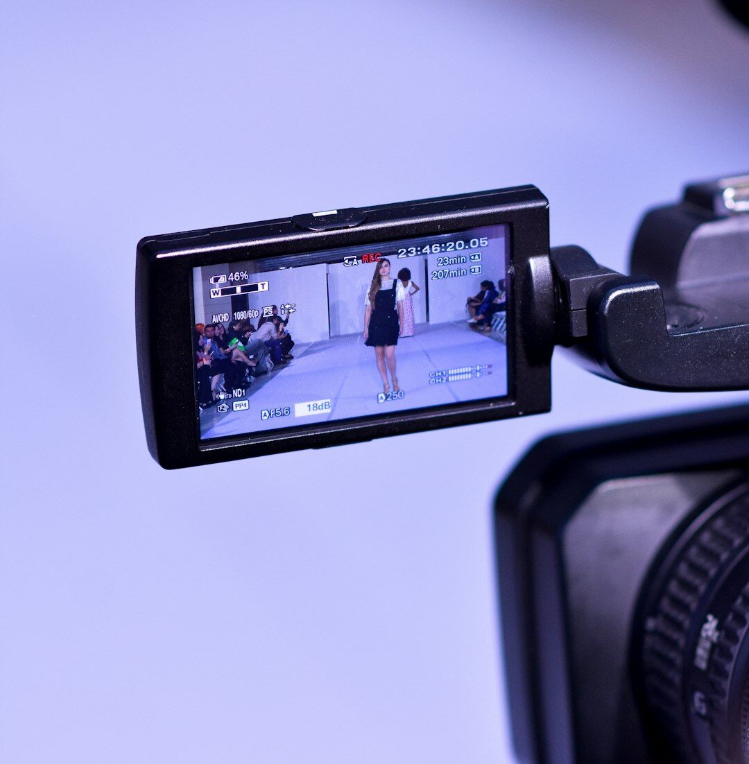 Instructor showing a student how to use a handheld camera